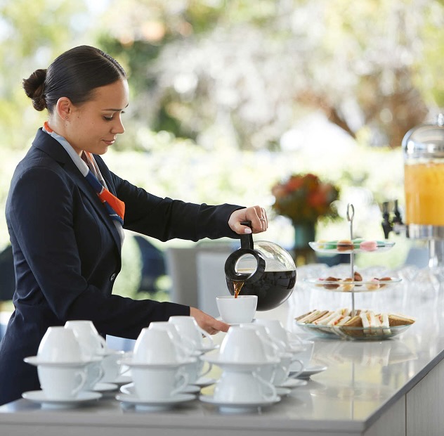 funeral director making a cup of coffee on a catering table