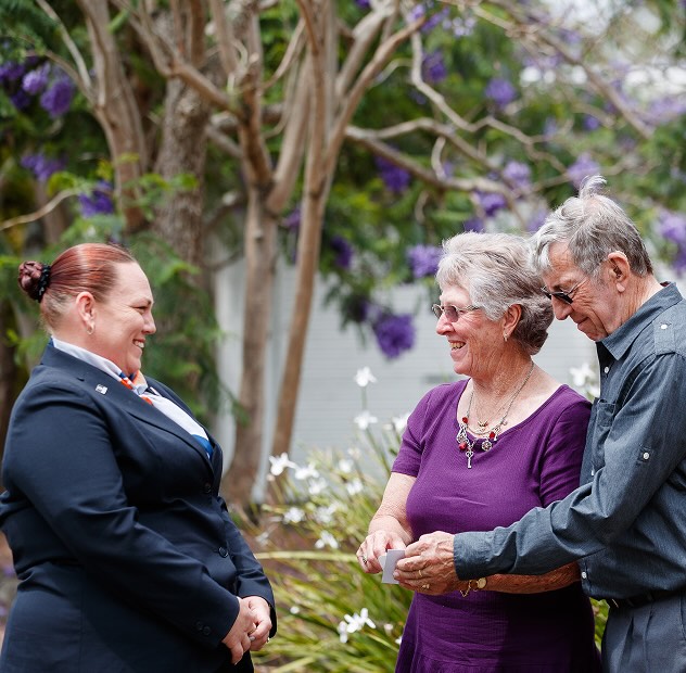 funeral director smiling at an elderly couple outdoors