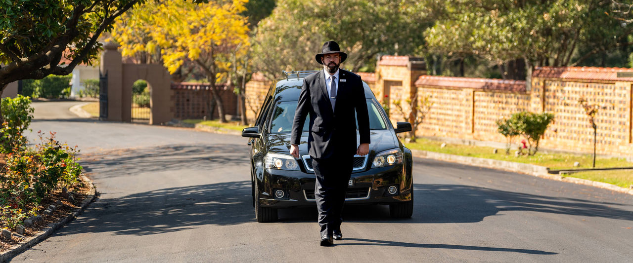 funeral director leading a hearse