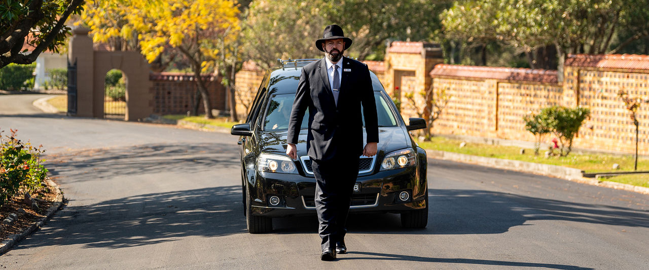 funeral director leading hearse